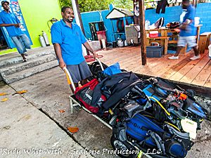 dive dominica dive staff taking dive gear to the boat